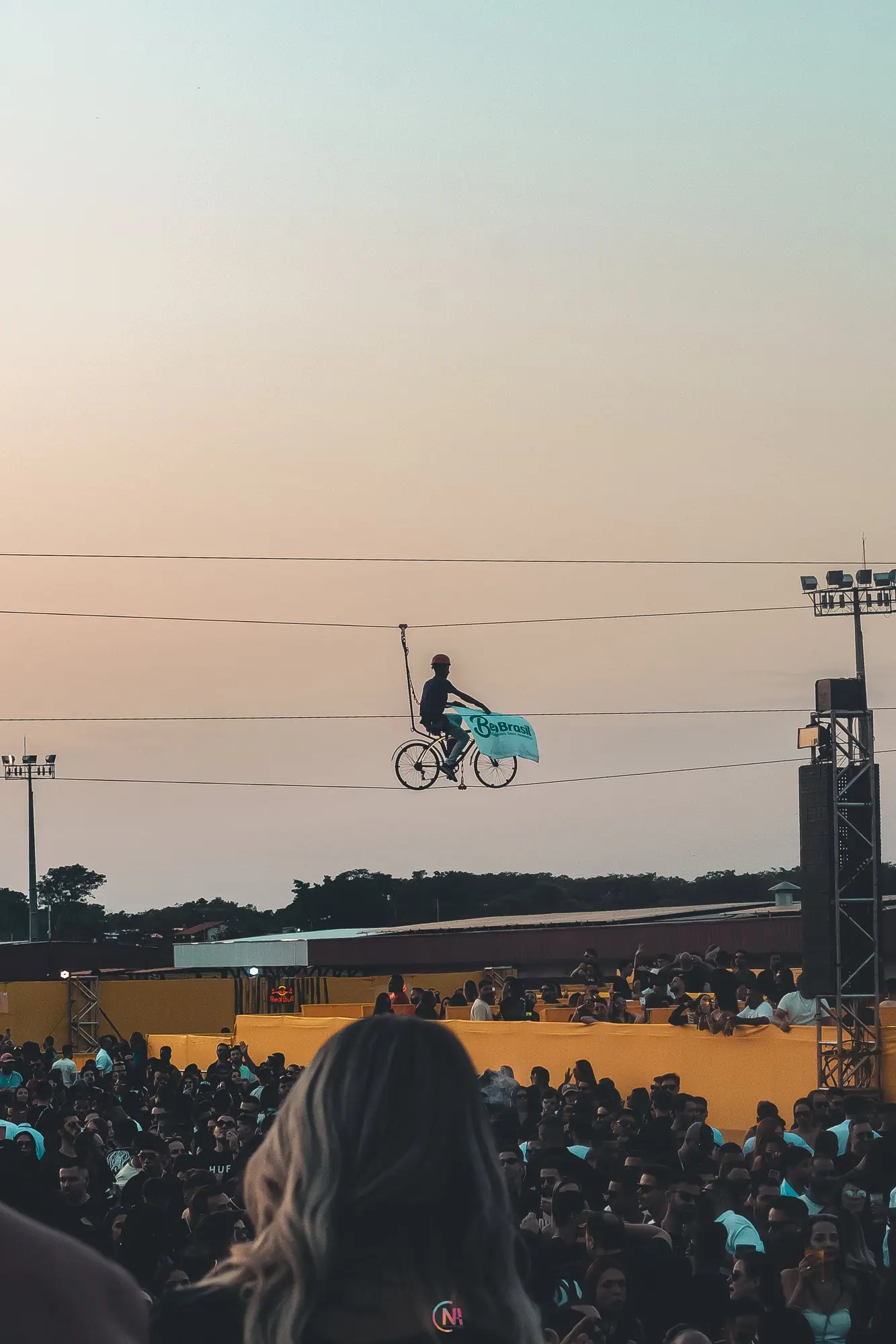 Sky Bike sobrevoando multidão em festival ao entardecer