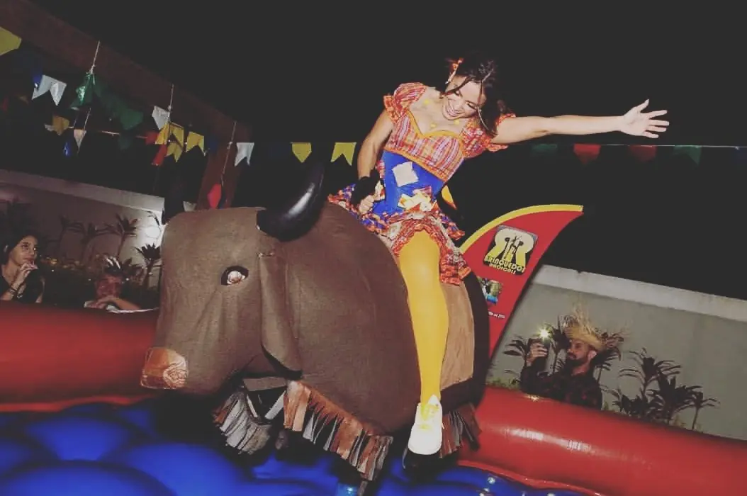 Mulher se divertindo no touro mecânico em festa junina